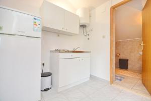 a kitchen with white cabinets and a sink at Apartmani Maća in Sikovo +29 photos