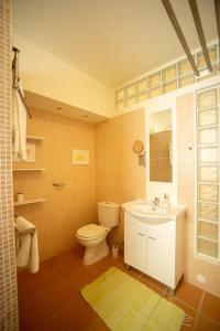 a bathroom with a toilet and a sink at Apartamento Troino in Setúbal +23 photos