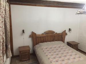 a bedroom with a wooden bed and two tables at Эко отель "Золотая подкова" in Sharhorod