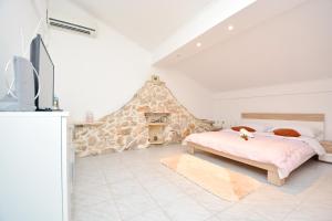 a bedroom with a bed and a stone wall at Apartmani Maća in Sikovo