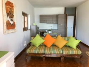 a living room with a couch with colorful pillows at Tramonto in Cà delle Isole in Stresa
