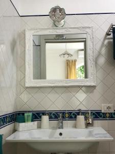 a bathroom with a white sink and a mirror at Casa Lara 2 in Positano