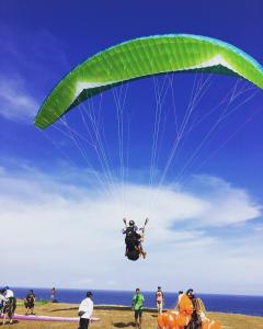 a person is falling off a parachute on the beach at El Homestay Bali in Nusa Dua