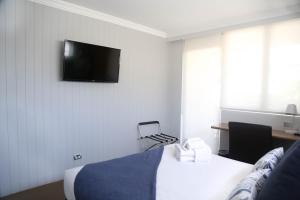 a hotel room with a bed and a television on the wall at The Blenheim in Sydney