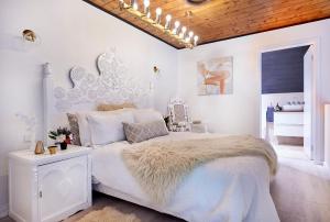 a white bedroom with a large bed and a chandelier at Church Conversion in Robertson