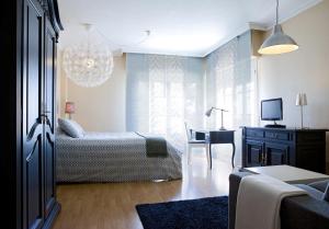 sala de estar con cama y escritorio con TV en TH Aravaca en Madrid