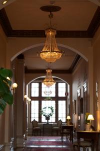 a large hallway with chandeliers and a large window at Teleborgs Slott in Växjö