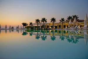 a resort with palm trees and a swimming pool at Capovaticano Resort Thalasso Spa in Capo Vaticano