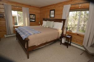 1 dormitorio con 1 cama en una cabaña de madera en Antler's Rest Bed and Breakfast en Glennallen