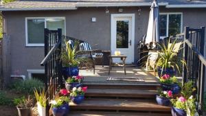 a patio area with a bench and some chairs at Campbell Cottage in Nanaimo