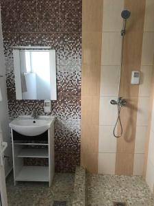 a bathroom with a sink and a mirror and a shower at Babylonia Resort in Costinesti
