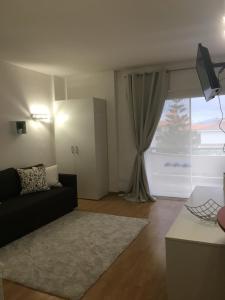 een woonkamer met een bank en een groot raam bij Estudio-Molino Blanco in Puerto de la Cruz