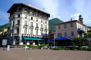 a large white building next to two other buildings at Cozy House Lake Como in Cernobbio