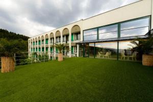 a large building with a lawn in front of it at RAYA Garden - Park Hotel & Winery in Veliko Tŭrnovo