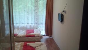 a room with two beds and a television and a window at Central Park Family Hotel in Kavarna +43 photos