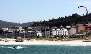 une personne pratiquant le kitesurf dans l'eau près d'une plage dans l'établissement Hotel Playa de Laxe, à Laxe