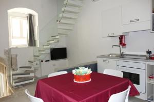 コラートにあるArco San Micheleのキッチン(テーブル、赤いテーブルクロス付)