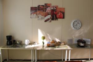 a table in a room with a clock on the wall at Guesthouse - Kuin Kotonaan in Kotka