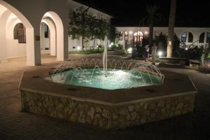 a fountain in the middle of a courtyard at night at Russian Pilgrim Residence in Sowayma