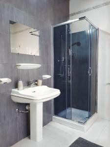 a bathroom with a sink and a glass shower at Villa Zammitella in St Paul's Bay