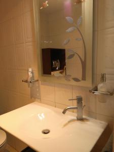 a bathroom with a sink and a toilet and a mirror at La casa de Marta in Murchante
