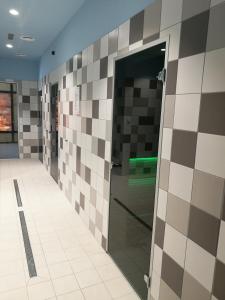a bathroom with brown and white tiles on the wall at Apartament 5Mórz Leo in Sianozety