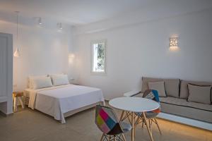 a room with a bed and a table and a couch at Anais in Mikonos