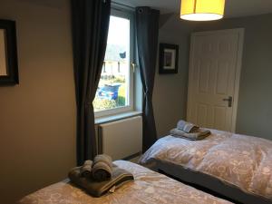 a bedroom with two beds and a window at 25 Windsor Crescent in Portree