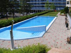 une grande piscine bleue sur un trottoir en briques dans l'établissement DElfin Apartmanház, à Balatonfüred