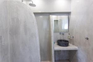 een badkamer met een wastafel en een spiegel bij Sunset Hotel in Firostefani