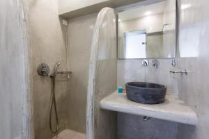 a bathroom with a sink and a shower at Sunset Hotel in Firostefani