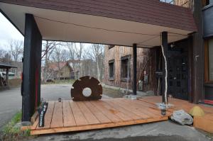 una gran terraza de madera fuera de un edificio en ARtINn 極寒藝術伝染装置, en Teshikaga