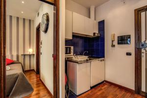 una cocina con armarios blancos y una pared azul en M&L Apartments - Ardesia Colosseo, en Roma