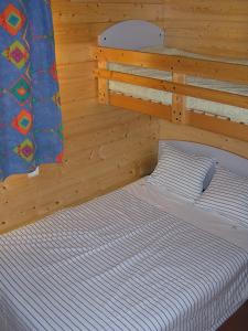 ヴェール・ポン・デュ・ガルにあるLe Mazet des Cigalesの木製の部屋にベッド1台が備わるベッドルーム1室があります。