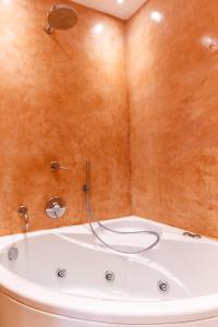 een badkamer met een bad en een douche bij Sunset Hotel in Firostefani