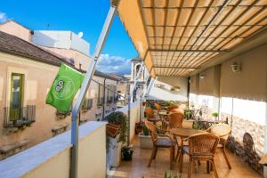 een balkon met tafels en stoelen en een vlag bij Casa Provenza in Catania