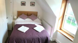 um quarto com uma cama com duas almofadas em Carrick House em Kingussie