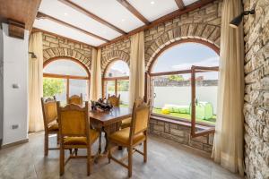 a dining room with a stone wall and arched windows at Holiday Home Oliva in Vodice