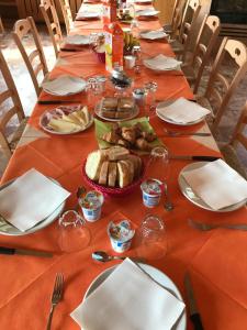 Albergo De Jean في Garzeno: طاولة طويلة عليها أطباق من الطعام