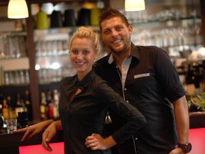 Ein Mann und eine Frau stehen an einer Bar in der Unterkunft Hotel Restaurant Jägerhof in Düren - Eifel