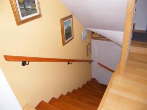 a stairway with a wooden rail on the wall at Apartment Mamut in Premantura