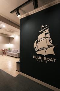 a black wall with a black and white ship on it at Blueboat Hostel Haeundae in Busan
