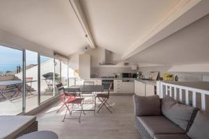 a kitchen and living room with a table and chairs at Coup de coeur: duplex centre ville vue mer & port in Bandol