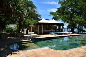 a swimming pool with a gazebo and a house at Mediterraneo Boutique Hotel in Dar es Salaam
