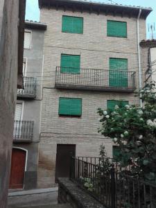 ein Gebäude mit grünen Fenstern an der Seite in der Unterkunft Casa Sariñena in Adahuesca