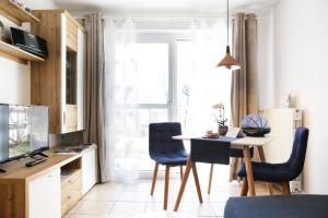 Fricks Appartement في Dölsach: غرفة معيشة مع طاولة وكراسي وتلفزيون