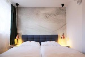 sypialnia z 2 białymi łóżkami i ścianą w obiekcie Fricks Appartement w mieście Dölsach