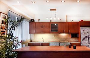 a kitchen with wooden cabinets and a wooden table at Saki's apartment in Athens