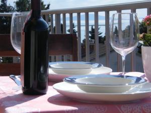 a table with a bottle of wine and plates and glasses at Apartment Mamut in Premantura