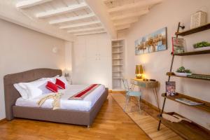 a bedroom with a bed with red pillows and a desk at MyTALE Apartment Luxury Navona in Rome